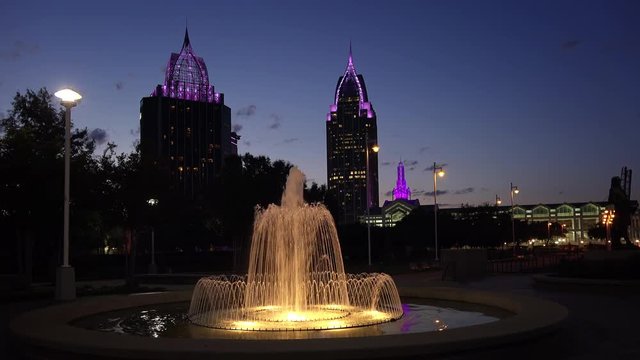 Downtown Mobile, Alabama skyline and water fountain as night falls in Cooper Riverside Park
