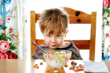 Boy making a face while eating breakfast cereal