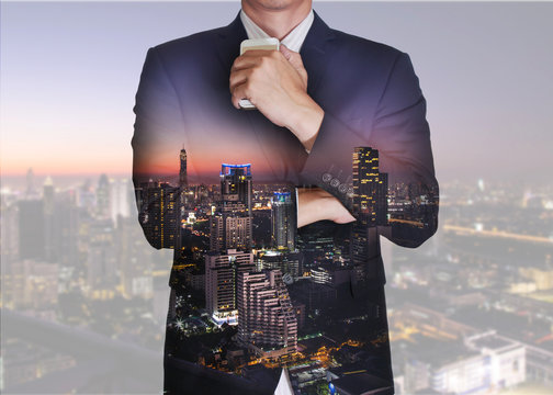 Double exposure of businessman stand up and think idea about business, cityscape, urban and street in the night or twilight as business and thoughtful concept.