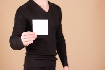 Man showing blank white square flyer brochure booklet. Leaflet p