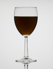 Tall wine glass with colored liquor on white background
