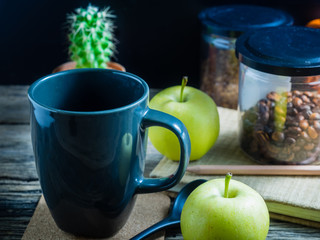 Coffee and apple on the table. During breaks eat fruit and a coffee is a good thing.