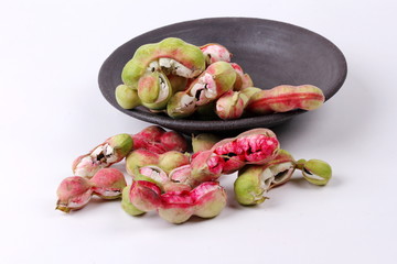 Manila tamarind  fruit on black dish .