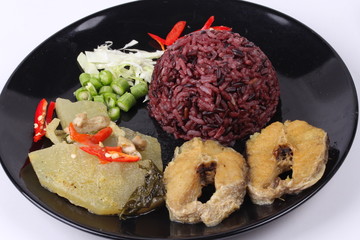 Brown jasmine rice topped green chicken curry and fish.