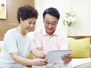 senior asian couple using tablet computer together