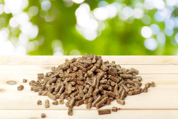 Wood pellets on a green background. Biofuels.