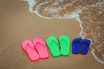 Fototapeta na wymiar family on beach concept - flip flops at sea