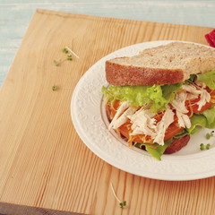 Homemade sandwich with chicken on a white plate