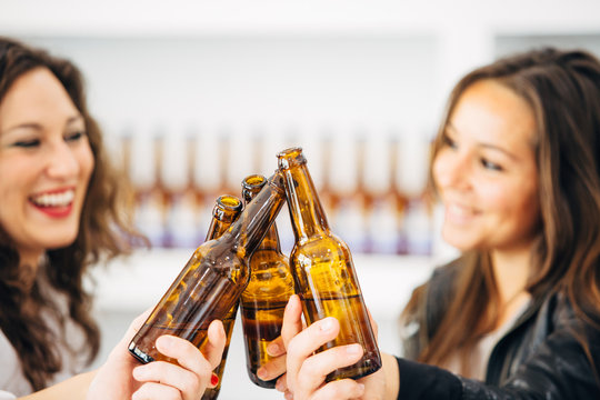 People clinking bottles of beer