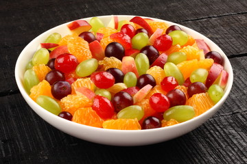  summer fruit bowl in black wooden background,