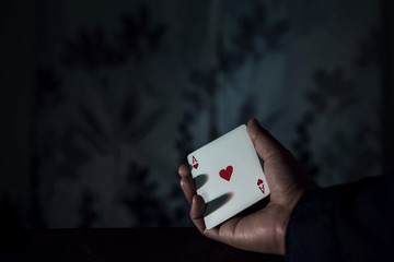 Obraz premium Ace Card in Hand, Chance or Risk of Love Concept, low-key lighting and selective focus on red heart