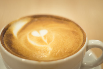Latte art coffee over wooden background