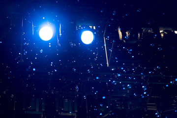 Bubbles and rays of blue light through the smoke on stage during theatrical performances.