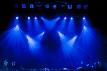 Lighting equipment on the stage. Blue rays of light through the smoke during theatrical...