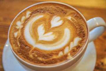 Big cup of cappuccino on a wooden background