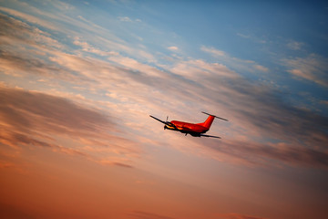 Naklejka na ściany i meble Airplane taking off at the sunset sky