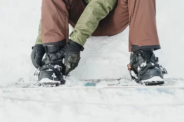 Foto op Plexiglas Man putting on his snowboard outdoor © Alex Photo