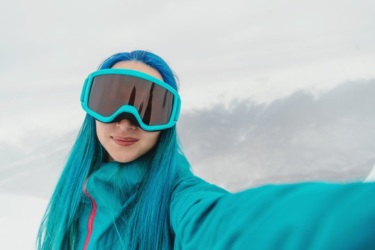 Snowboarder young woman doing selfie outdoor, pov