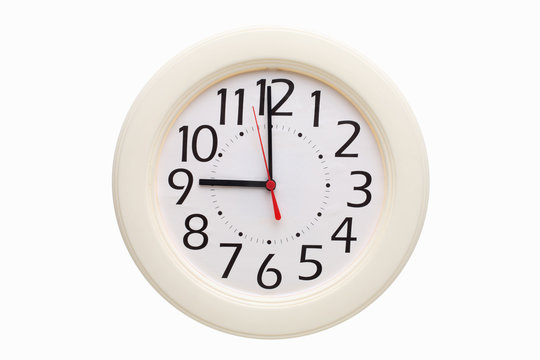 White analog wall clock showing nine o'clock