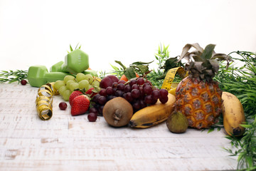 Fitness Konzept mit Früchten, Hanteln und Maßband