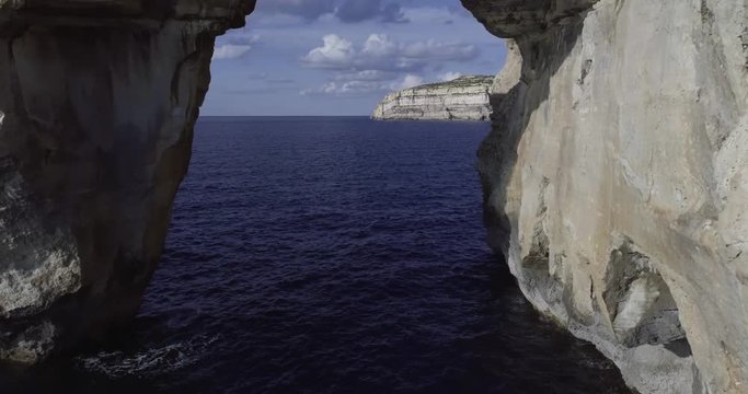 Gozo flight into the azure Window by drone sun and clouds
