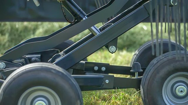 A machinery is lifting up and then it lowers down again. A farmer is checking it the machine is working properly.
