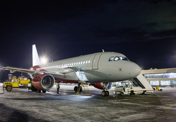 Fototapeta na wymiar Ground handling passenger airplane at night winter airport