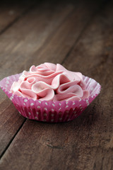 Schlagsahne in pink auf Holzplatte