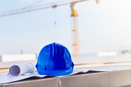 the blue safety helmet and the blueprint at construction site wi