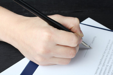 Male businessman's hand signs papers..