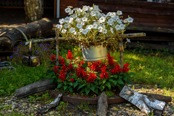 Decorative flower bed in the form of a fire with a pot and a kettle.