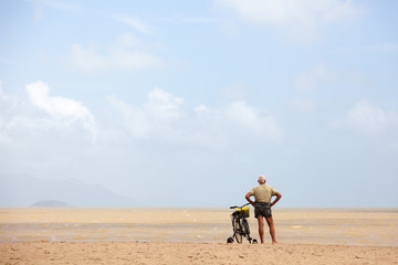 Obraz na płótnie Canvas Alone man with bicycle on the beach