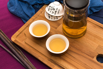 Green herbal tea in glass teapot on the blue wood background 