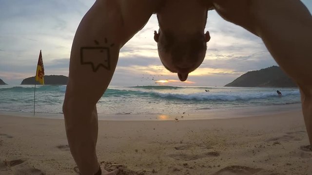 Young athletic man walks on his hands down sandy beach in Phuket, Thailand. Gopro selfie HD slow motion.