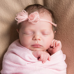 Newborn baby girl asleep on a blanket. Close-up