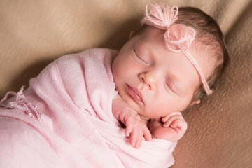 Newborn baby girl asleep on a blanket. Close-up
