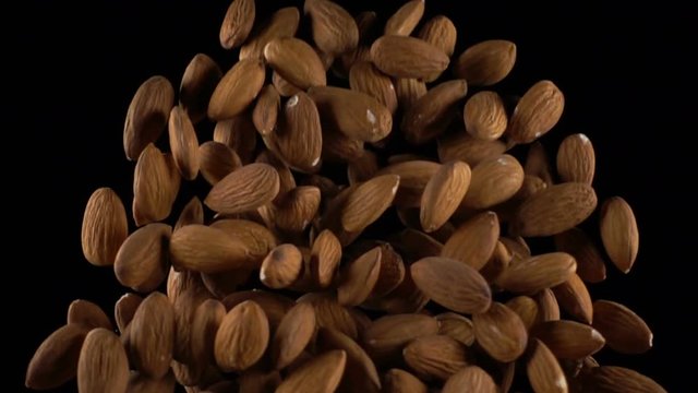 almonds in free fall on a black background