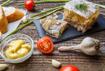Homemade jelly meat with mustard, bread, tomatoes and garlic on the table. Holodets