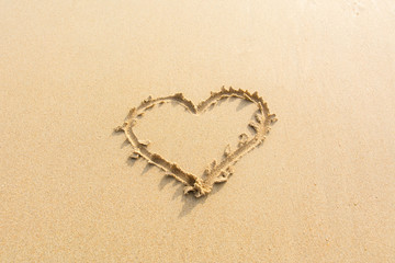 Obraz na płótnie Canvas Draw heart on beach. valentine day