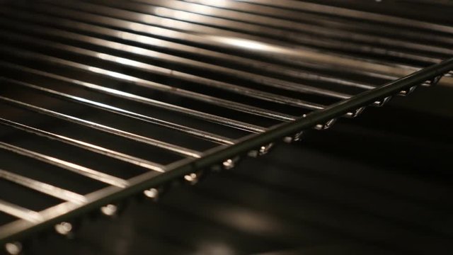 Thermally insulated stove components close-up 4K 2160p 30fps UltraHD tilting footage - Slow tilt on greasy electric oven walls and grid lighted 3840X2160 UHD video 