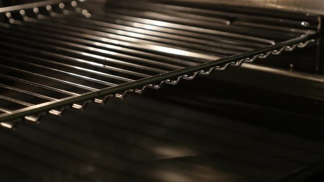 Close-up of thermally insulated stove components 4K 2160p 30fps UltraHD tilting footage - Slow tilt on greasy electric oven walls and grid lighted 3840X2160 UHD video
