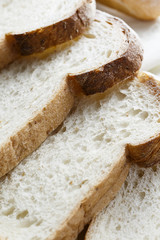 Fresh baked bread and sliced bread on rustic wooden table