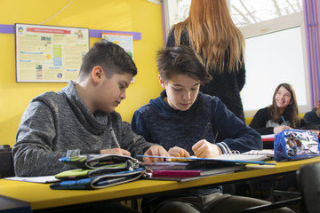 Group of school kids writing test in classroom