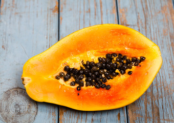 delad papaya ligger på turkos trä bakgrund