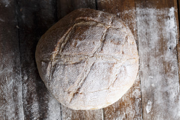 Fresh baked bread and sliced bread on rustic wooden table