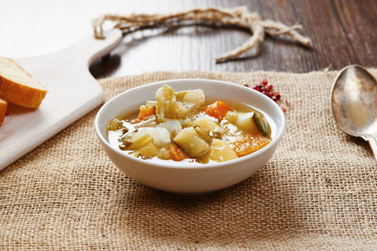 Vegetable soup on white bowl on wooden table
