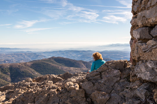 Kvinna njuter av utsikten fr&aring;n en h&ouml;g bergstopp