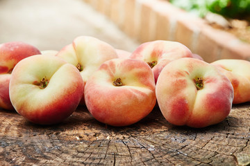 Peaches on old wooden, garden in background soft-focus