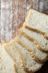 Fresh baked bread and sliced bread on rustic wooden table