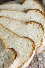 Fresh baked bread and sliced bread on rustic wooden table